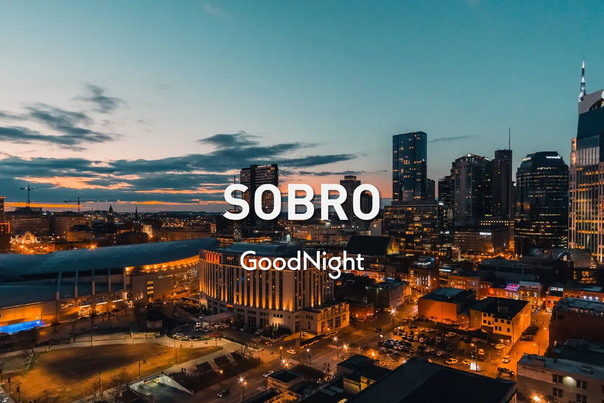 A sweeping view of the city skyline during sunset, with city lights beginning to twinkle. The vantage point suggests a rooftop or elevated outdoor space, emphasizing the panoramic urban views available to guests.